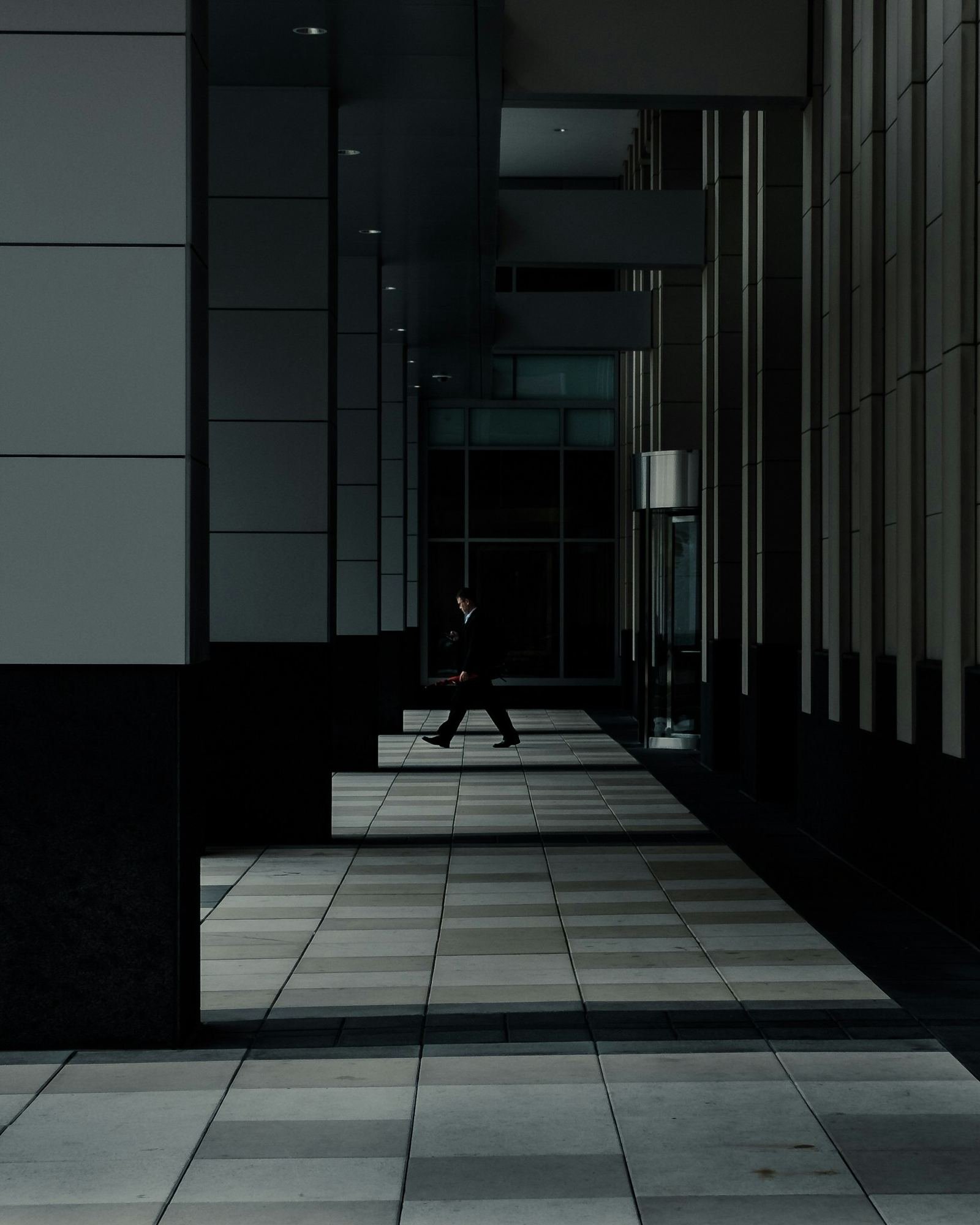 A person walking along a long office corridor