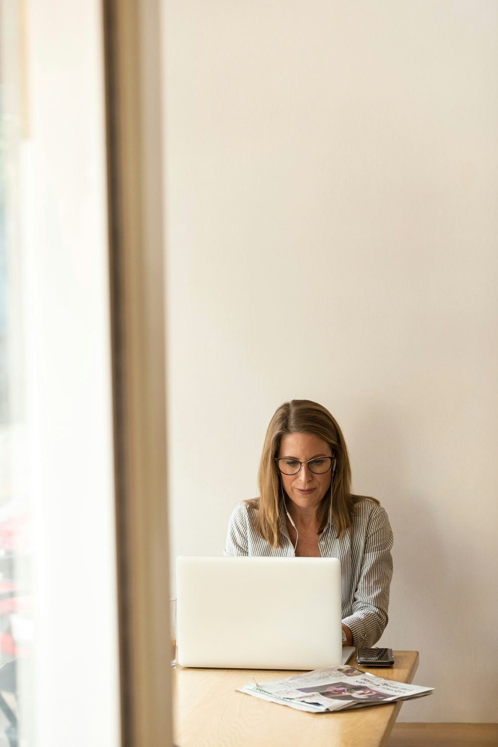 A business owner reading at a laptop by a window